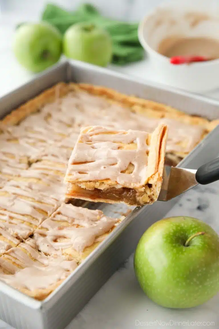 Scooping a piece of Apple Slab Pie out of a 9x13 inch pan.