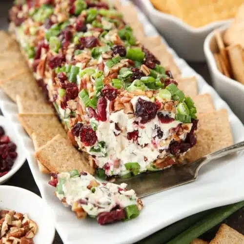 Cranberry Pecan Cheeseball shaped into a log with the inside showing.