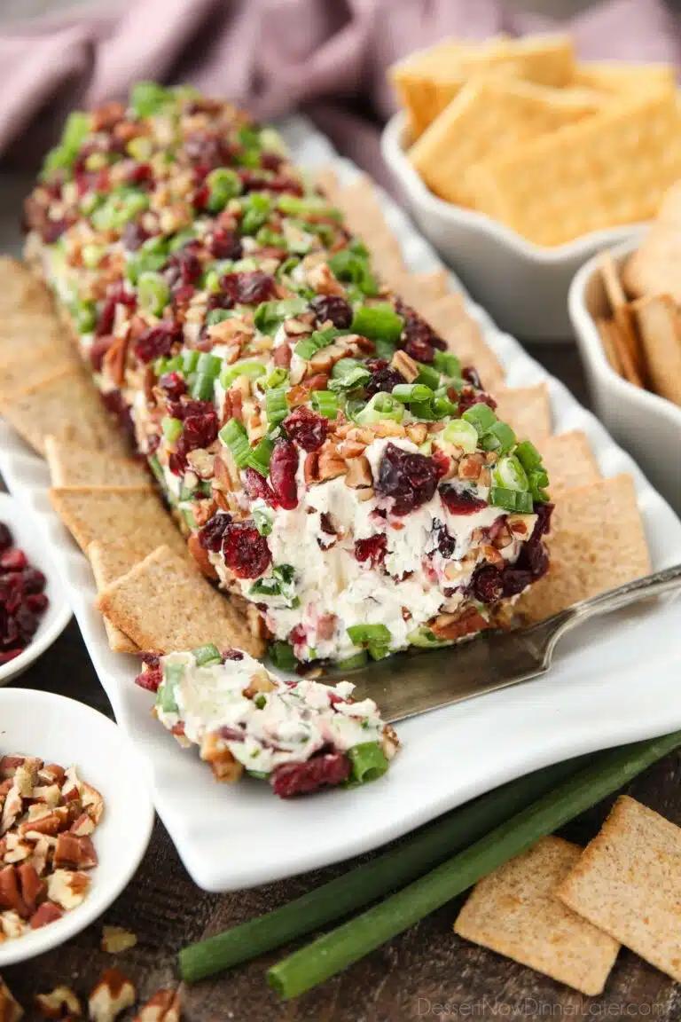 Cranberry Pecan Cheeseball shaped into a log with the inside showing.