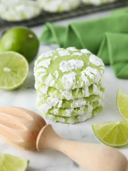 Stack of lime crinkle cookies with powdered sugar.