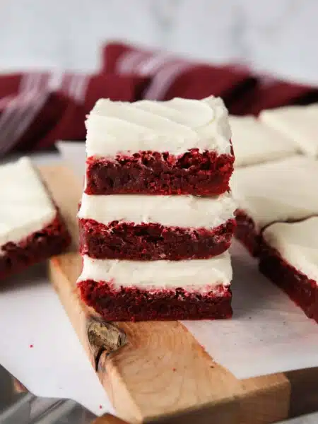 Stack of three Red Velvet Brownies with cream cheese frosting.