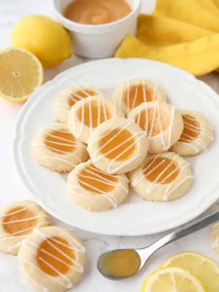 Plate of lemon curd cookies with glaze drizzled on top.