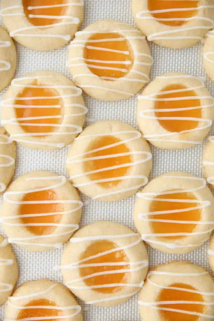 Shortbread cookies with lemon curd in the center and a powdered sugar glaze drizzled on top.