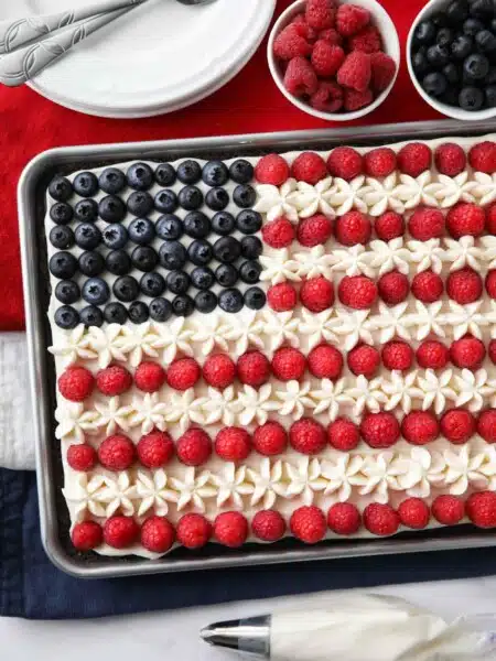 4th of July Fruit Pizza made with a brownie base and decorated with whipped cream cheese frosting, blueberries and raspberries for the stars and stripes.