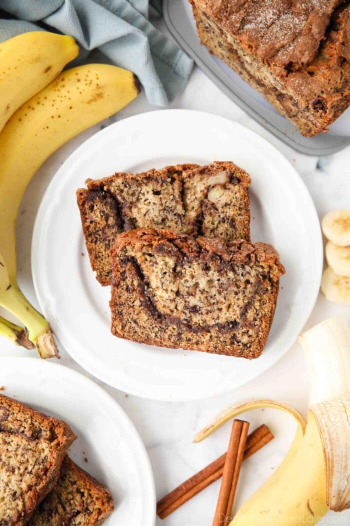 Two pieces of cinnamon swirl banana bread on a plate.