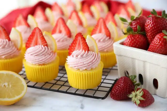 Strawberry Lemonade Cupcakes topped with slices of strawberries and lemons.