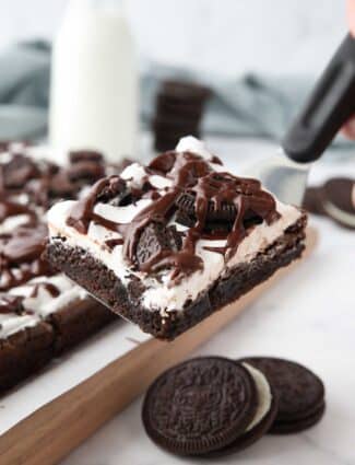 Scooping up a cookies and cream brownie with a spatula.