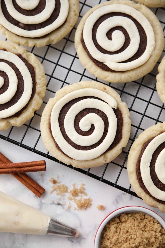 Top view of Cinnamon Roll Sugar Cookies with swirled frosting on a wire cooling rack.