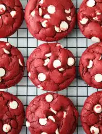 Red Velvet Cake Mix Cookies with white chocolate chips on a wire cooling rack.