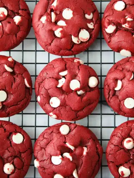 Red Velvet Cake Mix Cookies with white chocolate chips on a wire cooling rack.