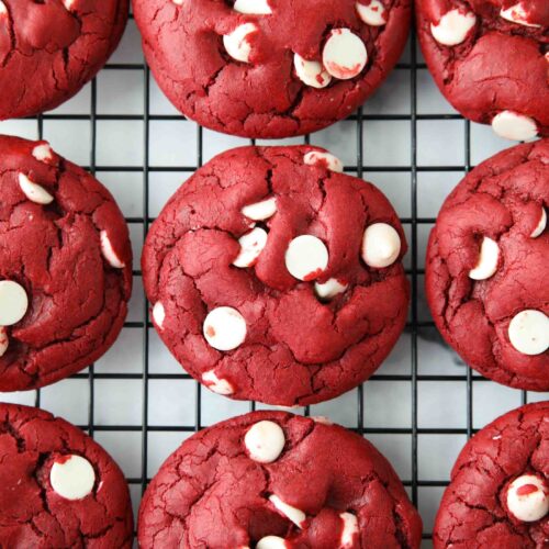 Red Velvet Cake Mix Cookies with white chocolate chips on a wire cooling rack.