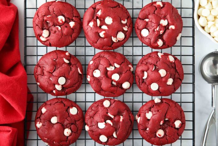 Red Velvet Cake Mix Cookies with white chocolate chips on a wire cooling rack.