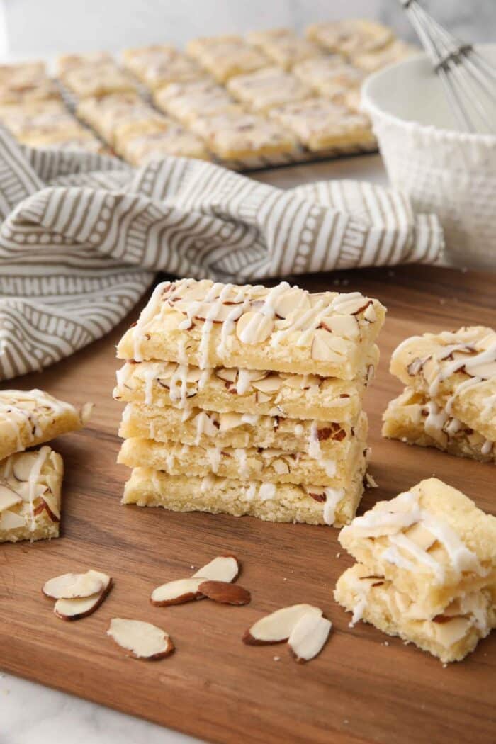 Almond Bars stacked on top of each other on top of a cutting board.