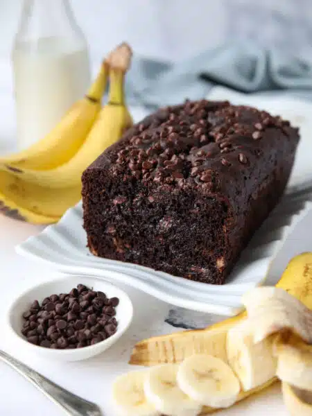 Chocolate banana bread with chocolate chips on a serving plate.