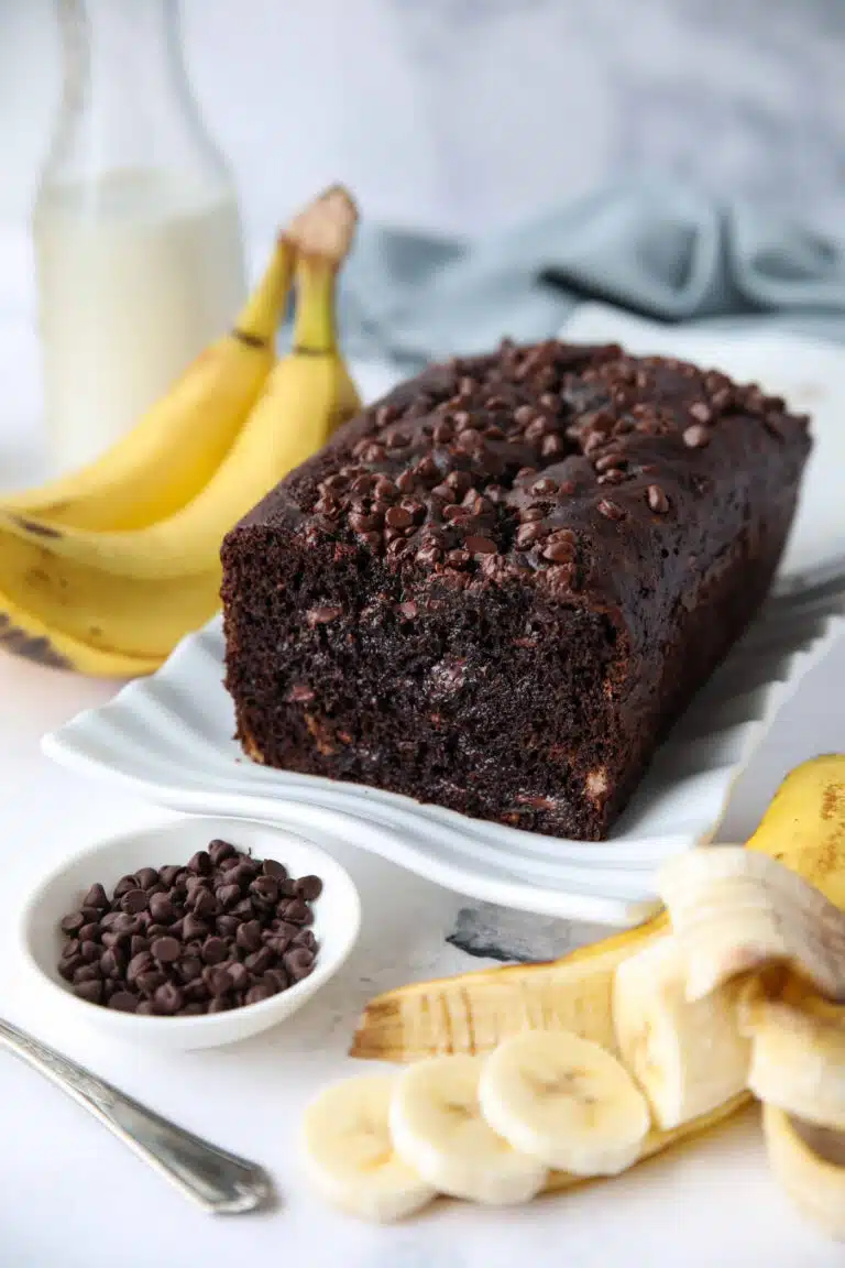 Chocolate banana bread with chocolate chips on a serving plate.