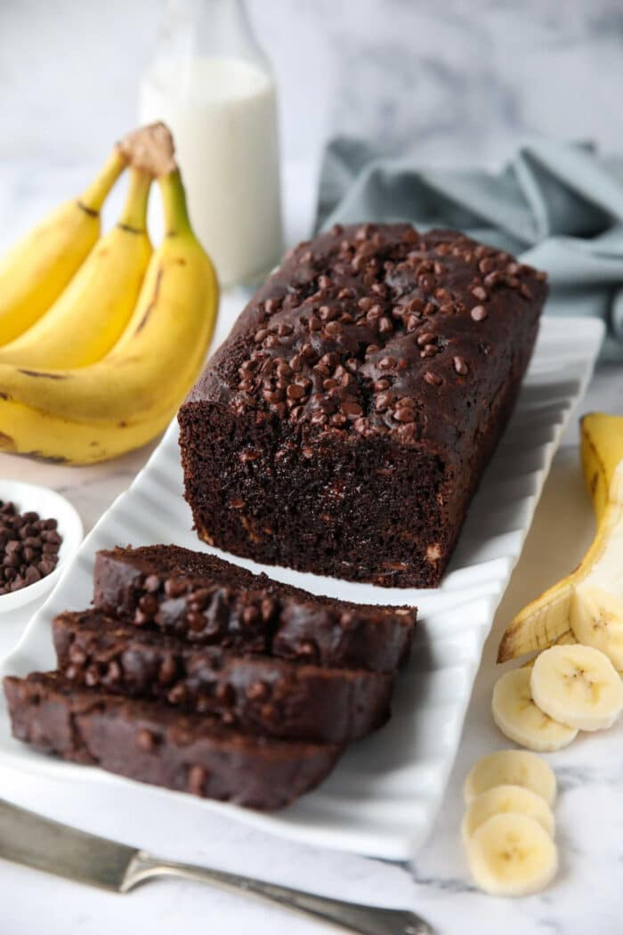 Chocolate Banana Bread on a serving plate with a few slices cut off the end.