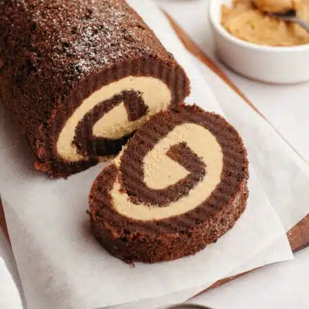 A slice cut off the end of a chocolate roll cake with peanut butter filling.