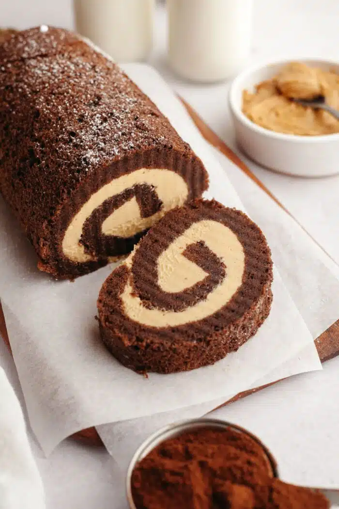 A slice cut off the end of a chocolate roll cake with peanut butter filling.