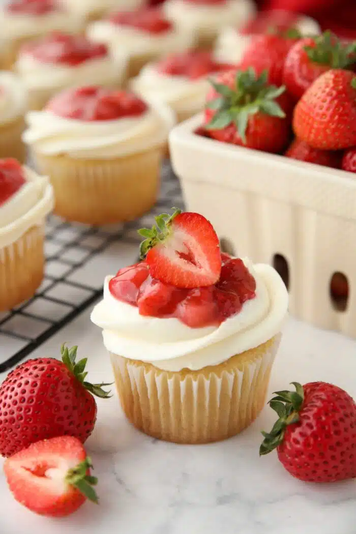 Valentine's Day Cupcakes with vanilla cake, whipped cream frosting, and fresh strawberry sauce.