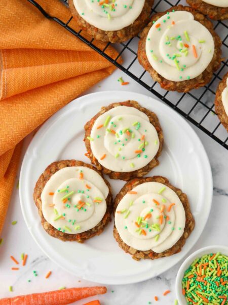 Carrot cake cookies with cream cheese frosting on a plate.