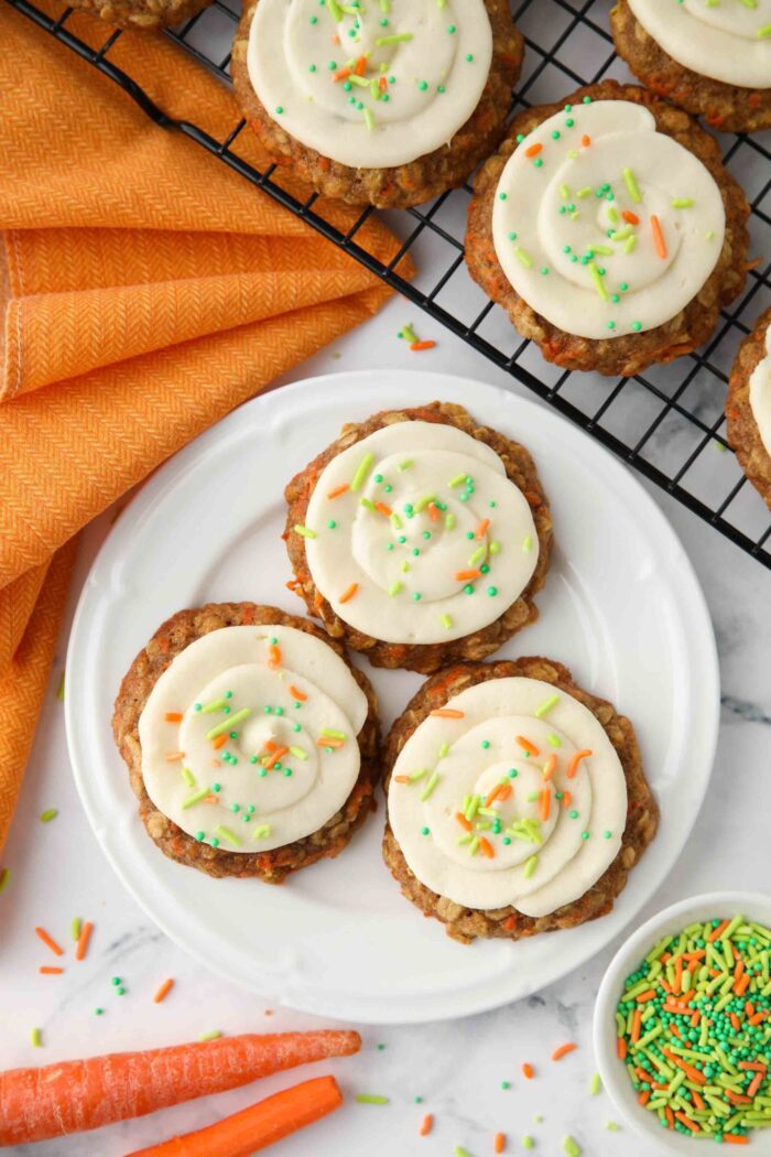 Carrot cake cookies with cream cheese frosting on a plate.