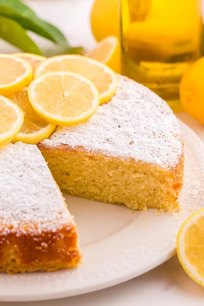 Close up of olive oil lemon cake with a slice removed showing the inside of the cake.