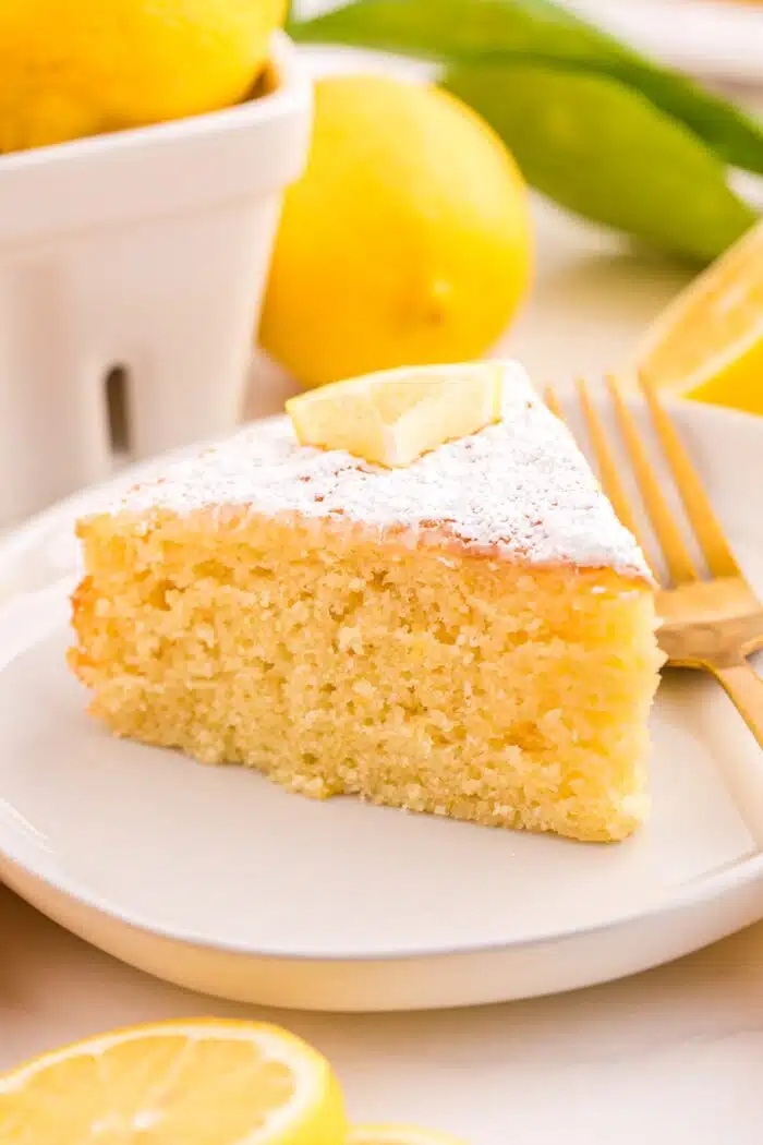 Close up of a slice of olive oil lemon cake on a plate.