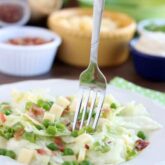 Sarah's Salad from Utah's Lion House restaurant uses crisp iceberg lettuce, peas, bacon, green onions, and swiss cheese tossed in a simple, sweet dressing.